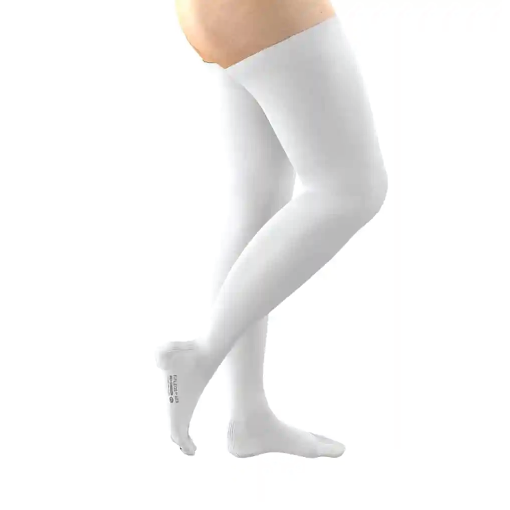 Side view of a pregnant person wearing white thigh-high compression stockings on both legs