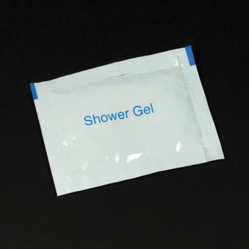 Small white shower gel sachet on a black background with blue text reading 'Shower Gel'