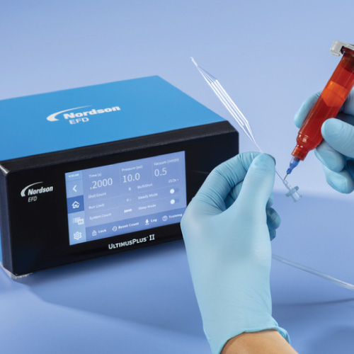 Close-up of gloved hands loading a syringe from a Nordson EFD UltimusPlus II dispensing device with a touchscreen display nearby.